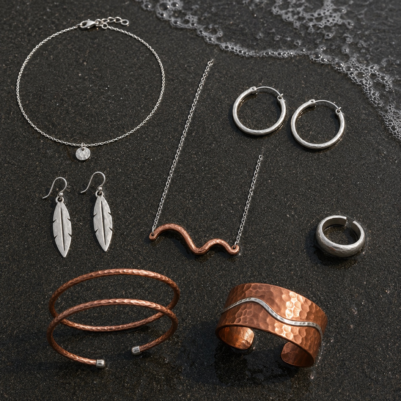 Early jewelry concepts on black volcanic sand: a wave necklace, leaf earrings, hoops and cuffs